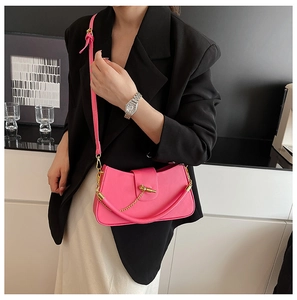 Detail of pink PU leather bag featuring gold spiral clasp and metal chain link handle