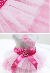 Detailed close-up of pink pet dress with mesh tutu layers and rhinestone bow accent