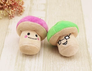 Detail of cute pink and green plush mushroom toys with embroidered faces and glasses