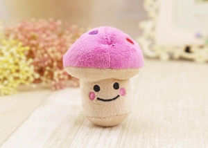 Close-up of a plush pink mushroom toy with colorful dots and a cute embroidered face