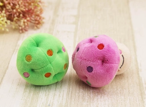 Detailed close-up of soft pink and green plush mushroom dog toys with colorful embroidery