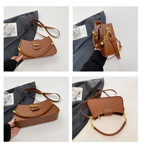 Detail view of brown PU leather crescent bag with gold chain and metal buckle