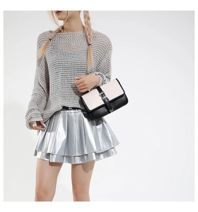 Detail view of stylish mini shoulder bag with metallic handle and silver pleated skirt