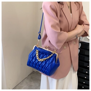 Detail of vintage navy quilted crossbody bag with gold chain and metal clasp