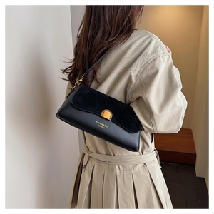 Detail of black vintage shoulder bag with textured suede patchwork and gold buckle