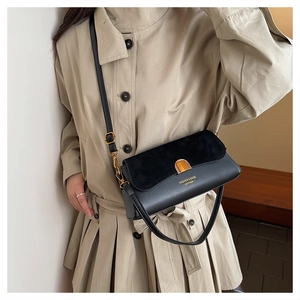 Detail of black patchwork shoulder bag showing metal clasp and adjustable leather strap