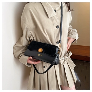 Detail of vintage baguette bag with gold buckle and stylish suede patchwork design