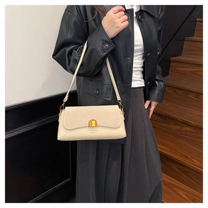 Detail of off-white baguette bag showing mixed leather texture and gold semicircular buckle