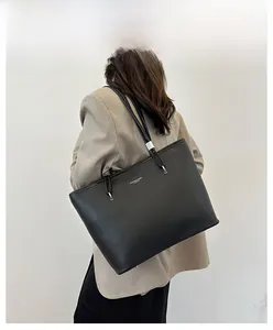 Dettaglio borsa tote nera con trama in pelle martellata e inserti metallici