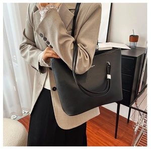 Dettaglio borsa tote in pelle martellata nera con finiture argentate e sottili spalline