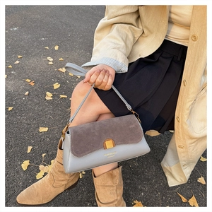Detail shot of the two-tone leather and suede stitching on the chic baguette bag