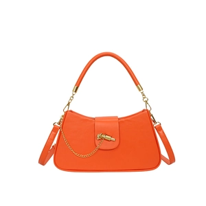 Chic orange box-shaped crossbody bag with gold chain and knot closure on white background