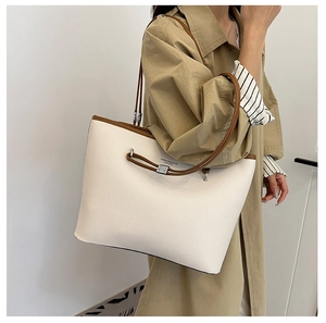 Dettaglio della borsa tote bianca con bordi marroni e scritta Fashion & Bags sulla modella
