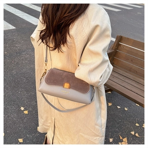 Detail of grey and brown shoulder bag featuring gold twist lock and leather texture