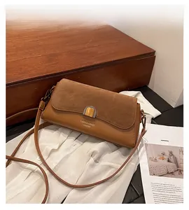 Detail of vintage baguette bag with suede flap and embossed fashion leather lettering