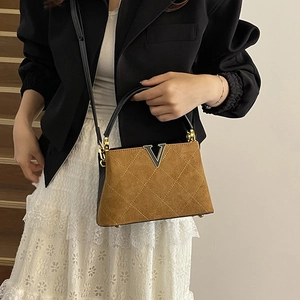 Brown quilted matte leather tote bag with V-shaped metal buckle and top handle