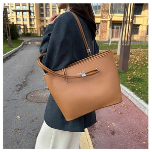 Dettaglio della borsa tote in pelle marrone con trama litchi e scritte in metallo argento