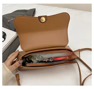 Interior view of tan crossbody bag showing zipper compartment and spacious capacity