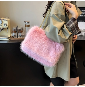 Elegante borsa a tracolla in ecopelliccia rosa con catena dorata in un caffè