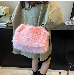 Pink faux fur shoulder bag with gold chain strap shown on model in a cafe setting