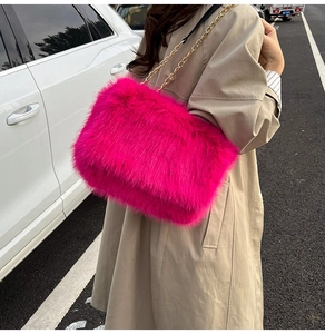 Detailed close-up of vibrant fuchsia faux fur shoulder bag with gold chain strap