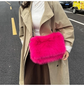 Detail of rose pink faux fur tote bag with golden metal chain strap in street style