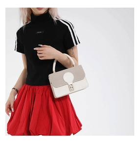 Detail showing the woven flap texture and metallic twist lock on this chic shoulder bag