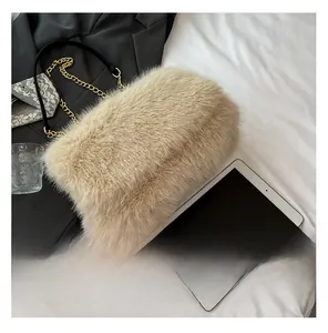 Detailed view of beige faux fur shoulder bag with gold chain and leather strap on white linen