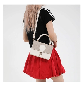 Detail of woven patchwork crossbody bag with metal lock and adjustable shoulder strap