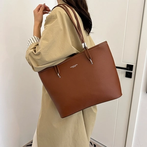 Borsa tote marrone in pelle con stampa FASHION & BAGS indossata da una modella elegante