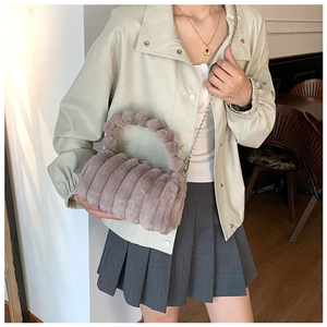 Détail du sac polochon en fausse fourrure mauve avec rayures et poignée peluche