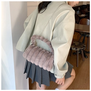 Détail du sac en peluche montrant la texture douce, les plis violets et la bandoulière
