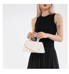 Detail of cream acrylic handbag with asymmetric flap and ergonomic silver metal handle