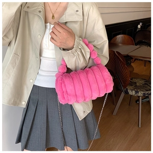 Détail du sac polochon rose pelucheux avec texture matelassée et chaîne argentée
