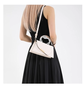 Detail view of white envelope bag with silver heart handle and golden metal trim accents