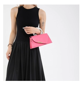 Detail of pink geometric crossbody bag with silver liquid metal handle on a model