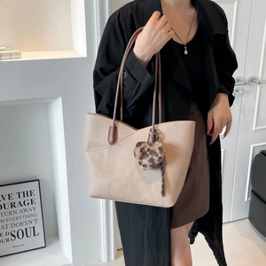 Chic beige leather tote bag with V-stitch design and leopard print heart charm accessory