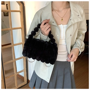 Détail du sac en fausse fourrure noire avec poignée perlée et chaîne en argent
