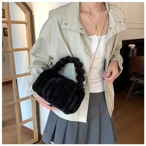Détail du sac polochon en peluche noire avec poignée bulle et bandoulière chaîne