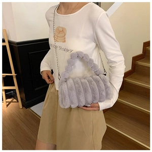 Détail du sac en fausse fourrure grise avec matelassage et fine bandoulière chaîne