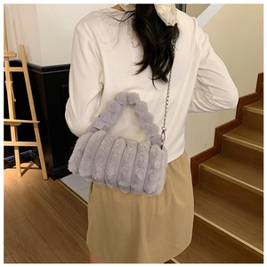 Détail du sac à bandoulière en fausse fourrure grise avec poignées et chaîne métallique