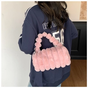 Détail du sac bandoulière en fausse fourrure rose avec poignée boules et chaîne en métal