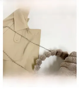 Détail du sac en peluche avec coutures ondulées, poignée en fourrure et chaîne argentée