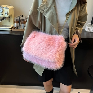 Elegante borsa tote in ecopelliccia rosa con catena dorata in un ambiente accogliente