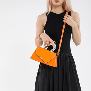 Chic orange leather crossbody bag with silver round handle and white stitching detail