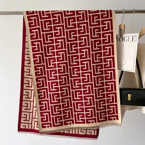 Detail of the red and beige geometric labyrinth pattern and tassel fringe on knit scarf