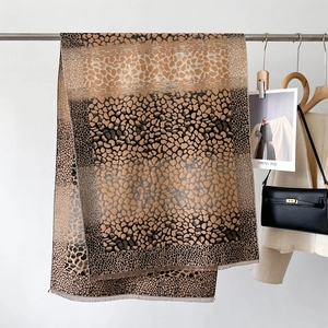Détail du motif léopard doux avec des franges élégantes sur une longue écharpe pashmina