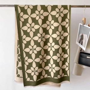 Dettaglio di sciarpa jacquard con frange verde scuro e spessa trama in maglia