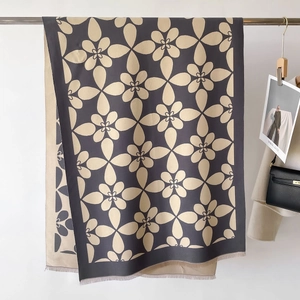 Dettaglio di sciarpa floreale con frange morbide e contrasto sofisticato blu e beige