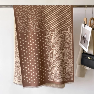 Dettaglio della sciarpa retrò con motivi paisley e pois e bordi con piccole frange